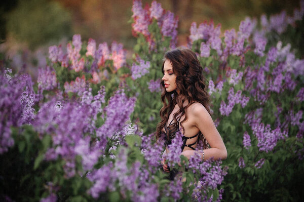 Beautiful young woman in a purple dress in the field