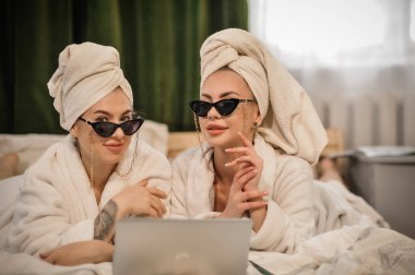 beautiful young women in bathrobes and bathrobe with towel in the spa center