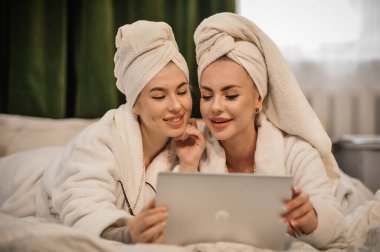 beautiful young women with her daughter in bathrobe and towel in bathrobes in spa center
