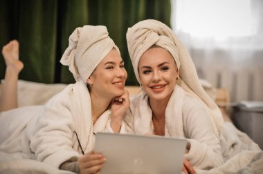 beautiful young women with towel in bathrobe and towels in spa salon