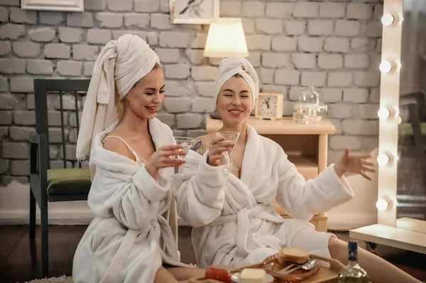 beautiful young women in bathrobes and bathrobe with towel in spa salon