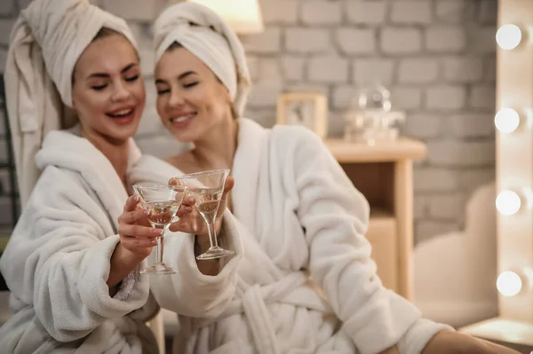 beautiful young women in bathrobes and bathrobe with towel in bathroom