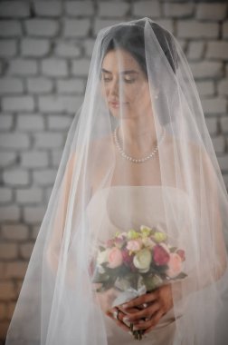 Duvağı ve gelinliği olan güzel gelin