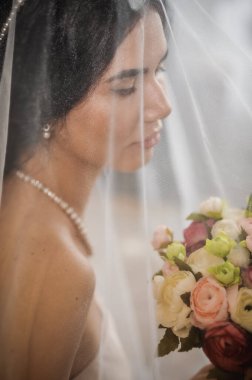 Duvağı ve düğün buketi olan güzel gelin