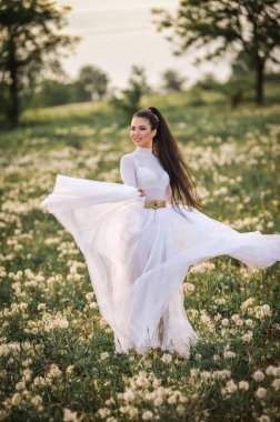 Parkta poz veren beyaz elbiseli güzel gelin