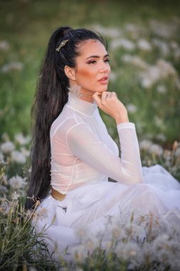 Beyaz elbiseli ve tarlada peçeli güzel bir gelin.