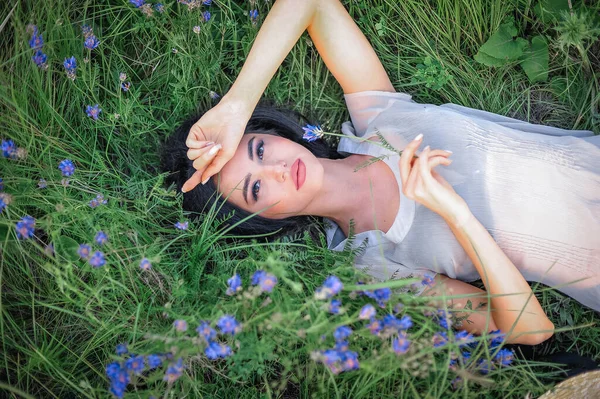 Tarlada çimlerin üzerinde uzanan güzel kız