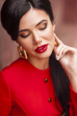 Kırmızı dudaklı ve uzun siyah saçlı güzel bir genç kadın. Model.