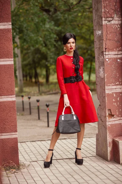 通りを歩く赤いドレスを着た美しい若い女性 — ストック写真