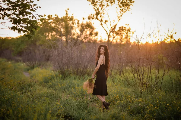 Parkta elbise giymiş güzel genç bir kadın.