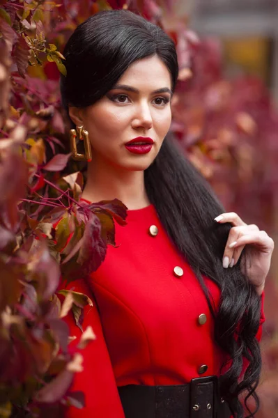 秋の公園でポーズをとる赤いドレスの美しい若い女性 — ストック写真