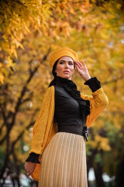 Güz parkında güzel genç bir kadın.