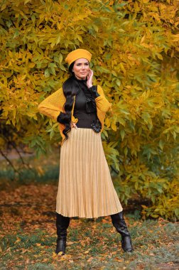 Güz parkında güzel genç bir kadın.