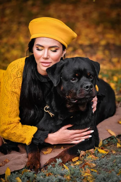 portrait of a young woman with a dog in the autumn park