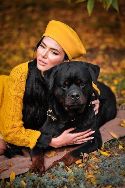 portrait of a young woman with a dog in the autumn park