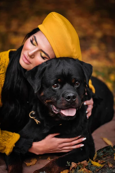 portrait of a young woman with a dog in the autumn park
