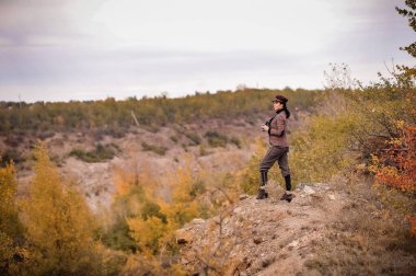 Sırt çantalı genç adam dağlarda yürüyüş yapıyor.