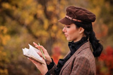 Sırt çantası ve haritası olan genç bir kadın sonbahar ormanında