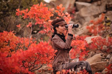 Ormanda dürbünlü genç bir kadın.