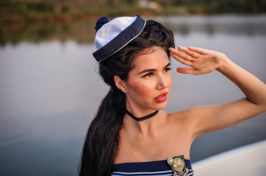 Siyah elbiseli ve plajda şapkalı güzel bir kadın.