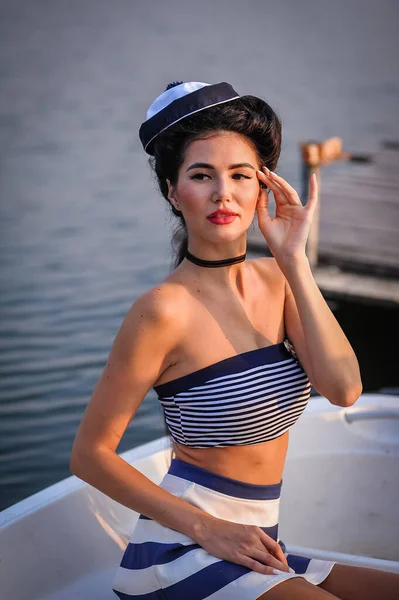 beautiful young woman in black bikini posing near yacht