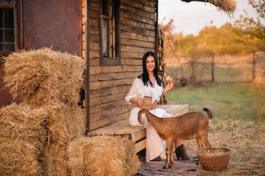 young woman with a dog in the hands of a goat