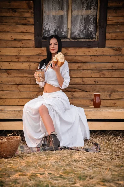 Beautiful Young Woman White Dress Hat Wooden Bench Old Village — Stock fotografie