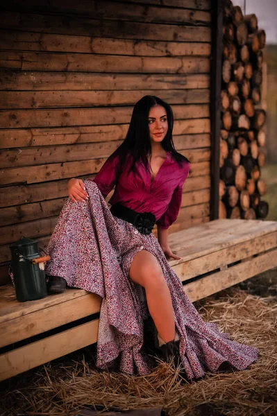 木製の背景に赤いドレスを着た美しい若い女性 — ストック写真