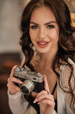 beautiful young woman with camera in hands on the background of a retro vintage film filter