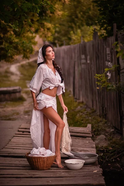 Piękna Młoda Kobieta Białej Sukience Kapeluszu Siedząca Drewnianej Ławce Ogrodzie — Zdjęcie stockowe