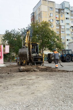 Tiraspol, Moldova - 14 Ekim 2021: Bir karayolu işçisi, Transnistria 'nın tanınmayan cumhuriyetinin başkenti Tiraspol' deki bir apartmanın avlusunda eski kaldırımları kazıyor