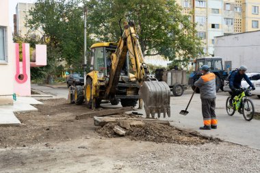 Tiraspol, Moldova - 14 Ekim 2021: Bir karayolu işçisi, Transnistria 'nın tanınmayan cumhuriyetinin başkenti Tiraspol' deki bir apartmanın avlusunda eski kaldırımları kazıyor