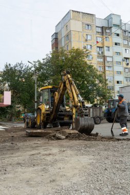 Tiraspol, Moldova - 14 Ekim 2021: Bir karayolu işçisi, Transnistria 'nın tanınmayan cumhuriyetinin başkenti Tiraspol' deki bir apartmanın avlusunda eski kaldırımları kazıyor