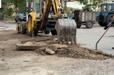 Tiraspol, Moldova - 14 Ekim 2021: Bir karayolu işçisi, Transnistria 'nın tanınmayan cumhuriyetinin başkenti Tiraspol' deki bir apartmanın avlusunda eski kaldırımları kazıyor