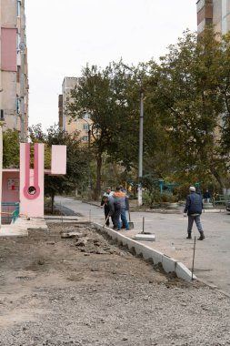 Tiraspol, Moldova - 15 Ekim 2021: Yol işçileri, Transnistria 'nın tanınmayan cumhuriyetinin başkenti Tiraspol' deki bir apartmanın avlusuna yeni beton kaldırımlar kurdular