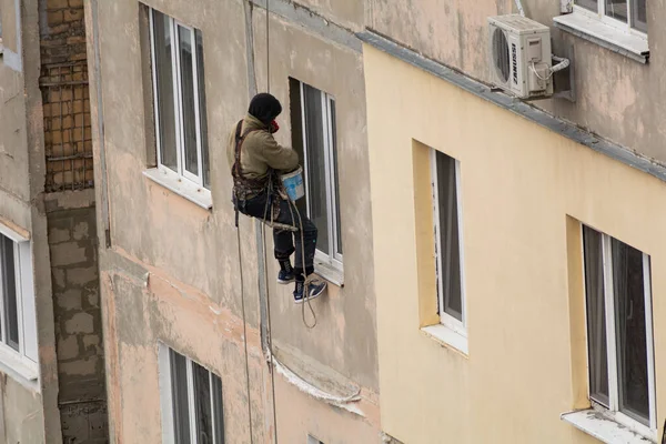 蒂拉斯波尔 摩尔多瓦 2021年11月19日 高层工程 一名工人爬上一幢公寓楼的墙完成窗户斜坡的景象 — 图库照片