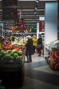 Chisinau, Moldova - 17 Ekim 2021: bir süpermarketin içinde. Vellmart süpermarketinin sebze reyonunda koruyucu maskeler takan müşteriler.