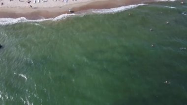 Manzaraya göre, birçok insan Karadeniz 'e yüzüyor ve dalıyor. Karadeniz kıyısı, Ukrayna. 4k orijinal video, 29.97 fps