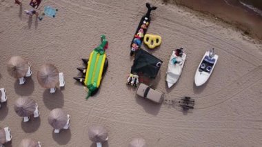 Motorlu tekne manzarası, deniz ve sahil şemsiyesi için şişirilebilir muz. Kuş gözünden deniz kıyısına doğru. Orijinal video Karadeniz Ukrayna, 4k, 29.97 fps.