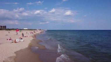 People Beach. Plaj insanları güneşleniyor, güneşleniyor, deniz kenarında dinleniyor. Deniz dalgaları altın kumu temizler..