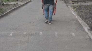 İnşaat işçisi inşaat alanında el arabasını kumla itiyor.