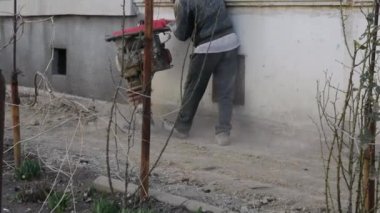 İşçi, evdeki kör bir alan için inşaat için taşınabilir titreşim rampası kullanıyor.