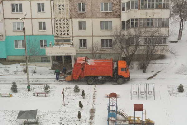 Garbage truck workers. Garbage removal in residential area, garbage men loading household rubbish in garbage truck