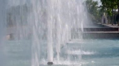Jets and splashes of water fountain in the park. Water pressure. High fountain in summer park. Splashing streams fountain. Strong spray of fountain water