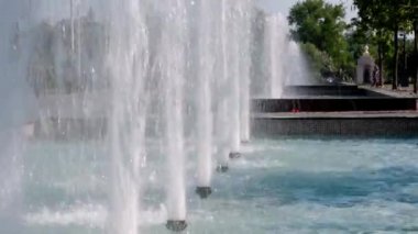 Gerçek zamanlı çeşme suyu. Parkta güzel bir çeşme var. Çeşme sıçraması. Su basıncı. Yaz parkında yüksek çeşme. Fıskiyeler fışkırıyor. Güçlü çeşme suyu serpintisi
