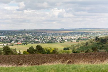 Tepeden köyün manzarası. Moldova köyü ve sonbahar bulutlu gökyüzü