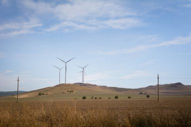 Rüzgar türbinleri tepede. Romanya 'nın rüzgar jeneratörlü güzel dağ manzarası. Yenilenebilir enerji kavramı.