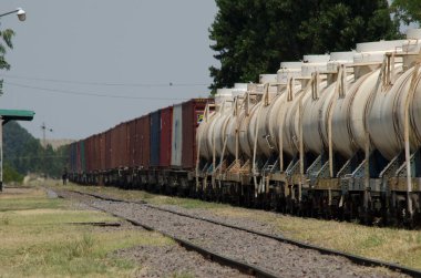Arjantin 'in kırsal kesimlerinde dolaşan zıt kutuplar ve yakıt tanklarıyla dolu uzun bir yük treni.