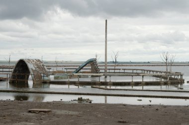 Epecuen sahilinde, gölün kıyısında. Çocuklar için kaydırağıyla yıkılmış şehir, savaş, üzüntü ve yalnızlık sahnesi