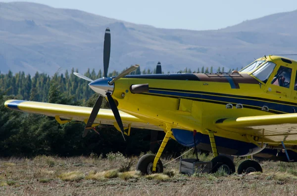 山の飛行場 黄色と青の消防車の飛行機に止められた — ストック写真